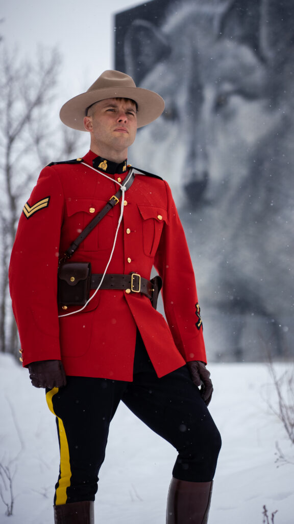 A Royal Canadian Mounted Police officer stands against the winter sky — duty and silence intertwined. Photo via Unsplash.
